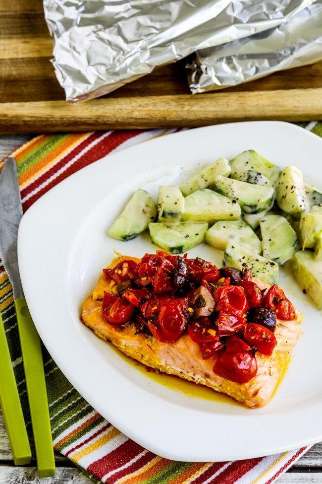 Paquetes de papel de salmón con tomates y aceitunas